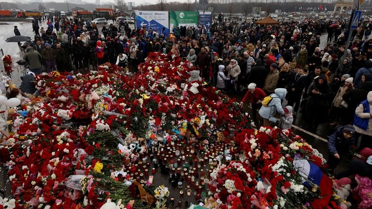 People gather at a makeshift memorial to the victims of a shooting attack set up outside the Crocus City Hall concert venue in the Moscow Re