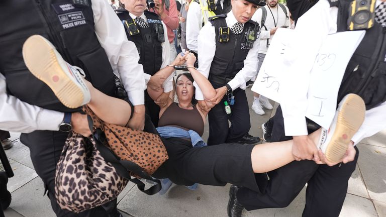 A woman is dragged away by police officers after attending the Palestine Action protest in Parliament Square. Pic: PA