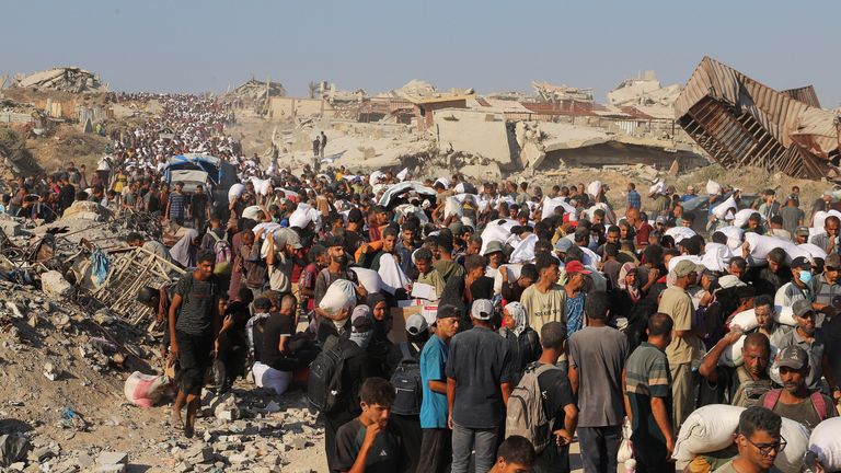 Palestinians carry aid supplies that entered Gaza through Israel, in Beit Lahia. Pic: Reuters