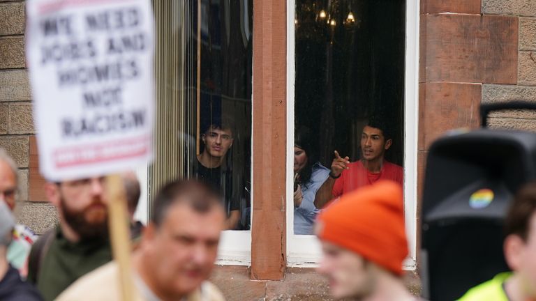 People inside the hotel look at protesters outside the Radisson Hotel in Perth. Pic: PA