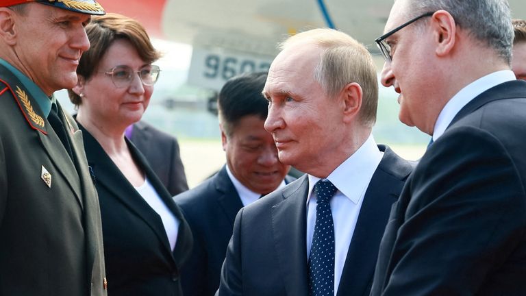Vladimir Putin shakes hands with officials during a welcoming ceremony in China. Pic: Reuters