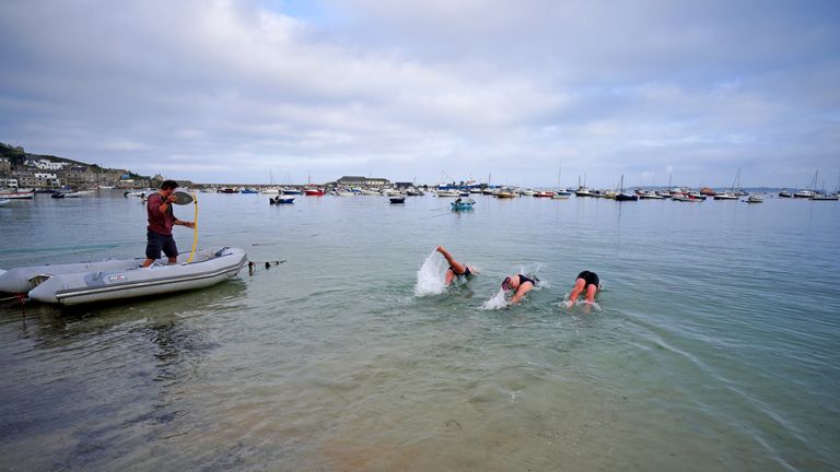 Swimmers take to the water from a beach in Hugh Town,  Isles of Scilly as amber heat health warnings have been issued across large swathes of England. Pic: PA