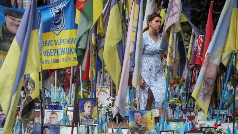 A woman visits a makeshift memorial with the names of fallen service members written on Ukrainian flags, at the Independence Square, amid Ru