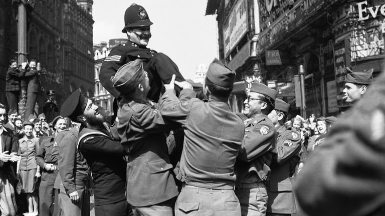 Yeni Zelanda denizcisi ve üç CBS, Japon teslim teklifini dinledikten sonra Piccadilly Circus'ta bir polis memuru. Dosya Pic: AP