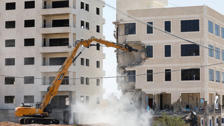 Israeli heavy machinery demolishes a Palestinian building near Bethlehem in the Israeli-occupied West Bank. Pic: Reuters/Mussa Qawasma