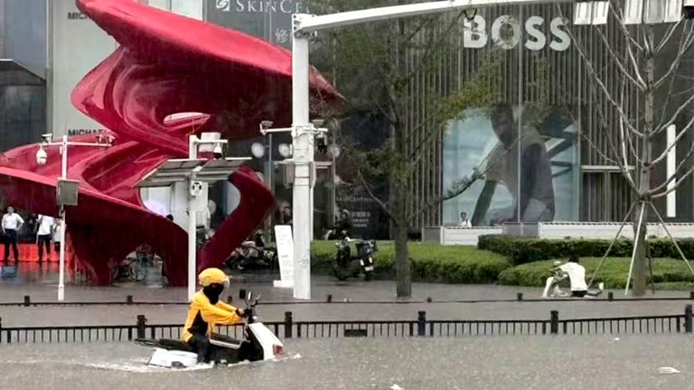 A delivery rider moves across a flooded road in Zhengzhou.
Pic: Chinatopix/AP