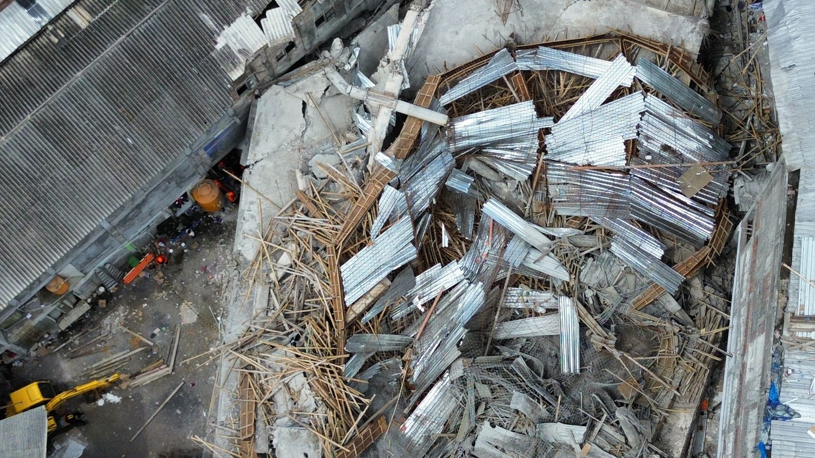 Three dead and dozens feared still trapped after school building collapses