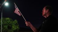 Greg Cronin holds an American flag at a growing vigil for Charlie Kirk outside Timpanogos Regional Hospital after Kirk was shot and killed Wednesday, Sept. 10, 2025, in Orem, Utah. (AP Photo/Lindsey Wasson)