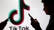 Teenagers in front of a TikTok logo. File pic: Reuters