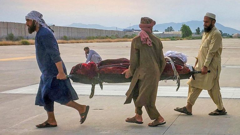People carry an earthquake victim on a stretcher to an ambulance at an airport in Jalalabad. Pic: Reuters