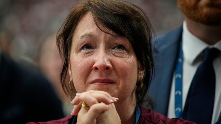 A woman is overcome with emotion while watching a Charlie Kirk tribute video. Pic: AP