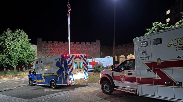 Ambulances park outside a hotel acting as a reunification centre after the shooting. Pic: AP