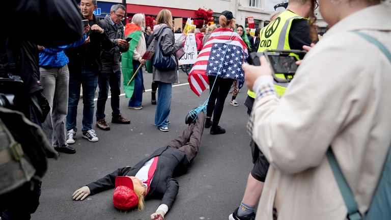 A campaigner drags a mannequin dressed like Trump along the ground. Pic: PA