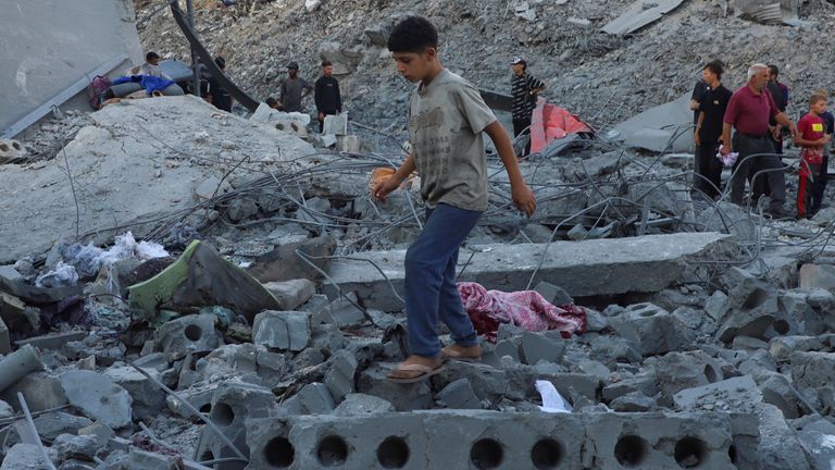 Palestinians inspect the site of deadly overnight Israeli strikes on a building where displaced people were taking shelter. Pic: Reuters