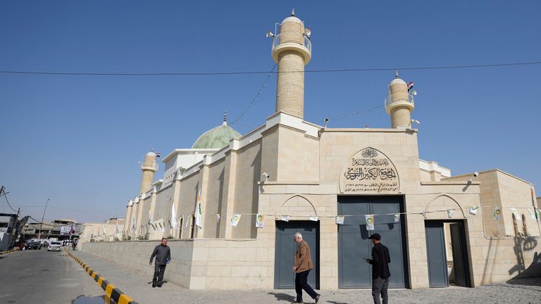 Iraklılar, yeniden açıldığı gün tarihi Al Nuri Camii'nin önündeki sokakta yürüyorlar. Pic: AP