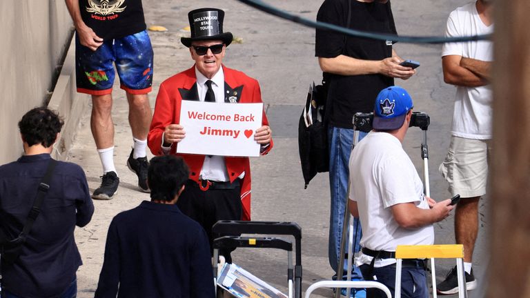 Gregg Donavan, talk show sunucusunun TV'ye döndüğü stüdyo dışında Jimmy Kimmel'i destekleyen bir işaret tutuyor. Pic: AP