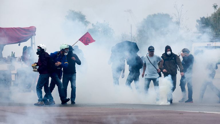 Protestujący stoją wśród gazu łzawiącego spryskany przez policję. Zdjęcie: Reuters