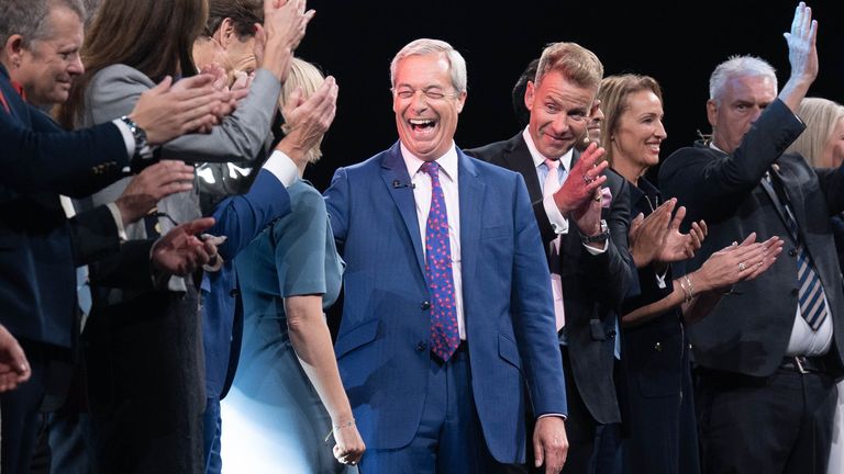 Reform UK leader Nigel Farage is joined by Reform MPs and members at the end of the party's annual conference. Pic: PA