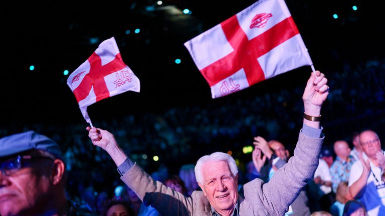 A man holds English flags as he attends the conference. Pic: Reuters