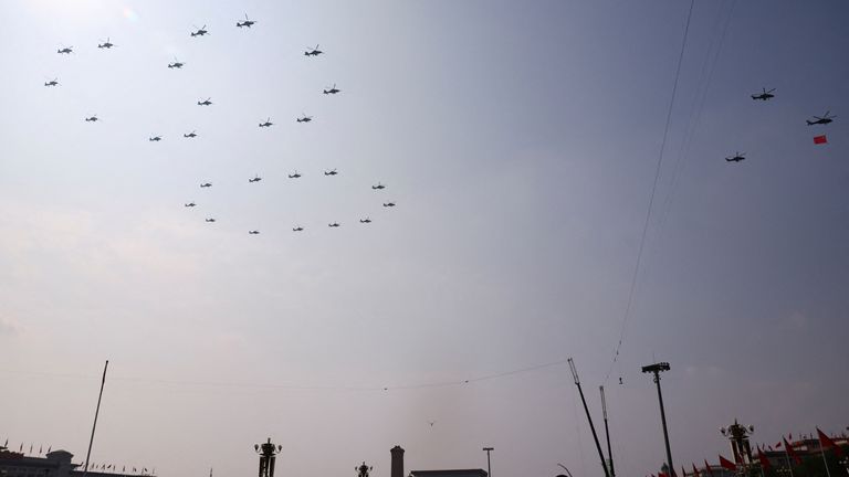 Military helicopters fly in the formation of the number 80 over Tiananmen Square. Pic: Reuters
