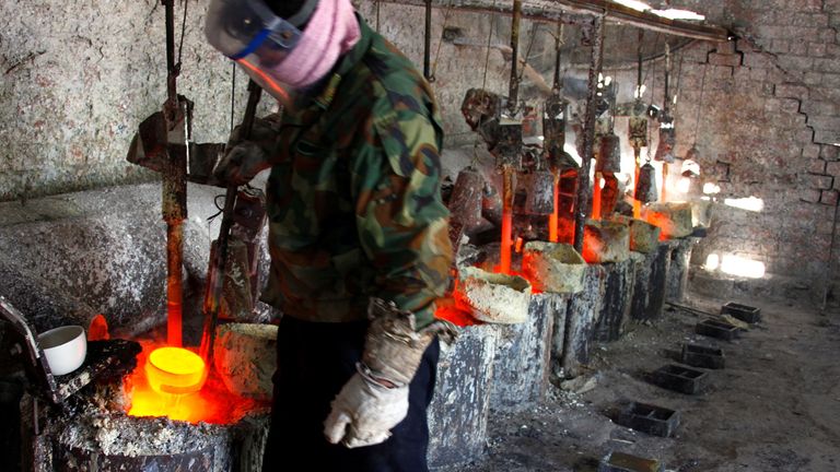 A worker prepares to pour the rare earth metal Lanthanum into a mould in a workshop in Inner Mongolia. File pic: Reuters