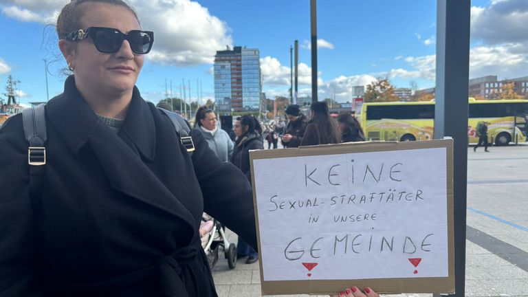 A protester holds a sign reading 'No sex offenders in our community'