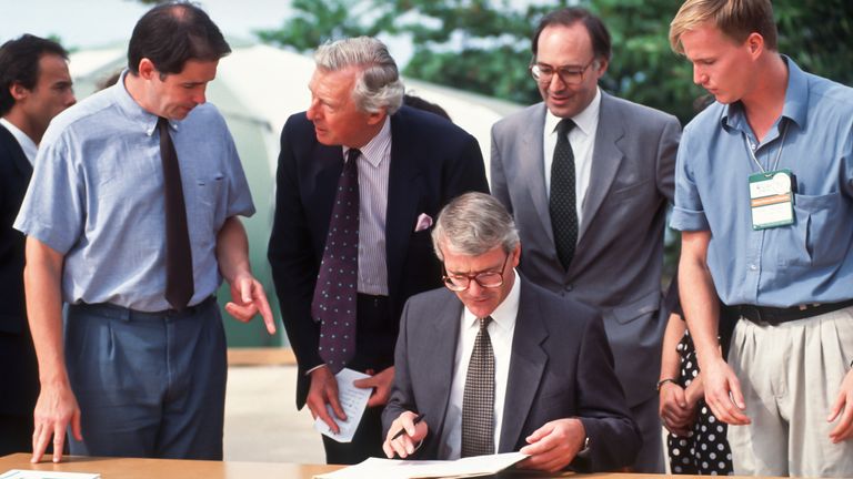 Michael Howard, second from right, standing behind then prime minister John Major, seated, writing his pledged at the Earth Summit in 1992. Pic: Alamy