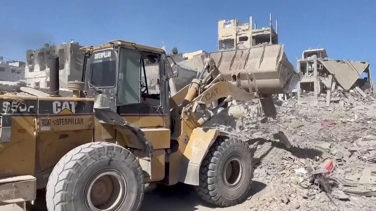 A bulldozer moves rubble