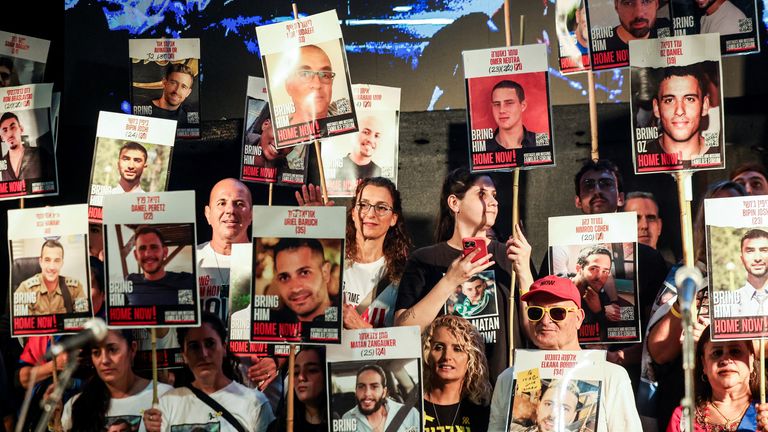 People in Hostages Square hold placards with pictures of the remaining hostages. Pic: Reuters