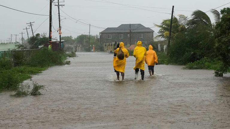 People walk along a road during the passing of Hurricane Melissa in Rocky Point, Jamaica, on Tuesday. Pic: AP