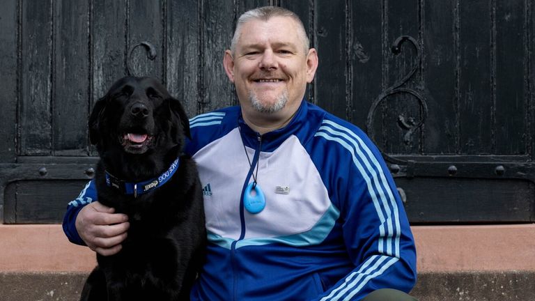 John Davidson MBE, with his black Labrador Suki. Pic: StudioCanal 