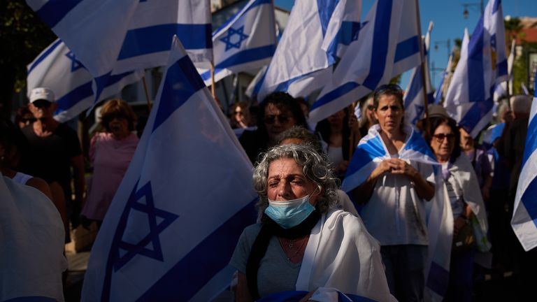 Mourners walk near the car carrying the coffin of slain hostage Guy Illouz during his funeral procession in Rishon Lezion, Israel.
