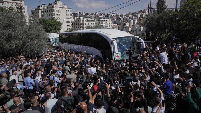 A crowd gathers around a bus carrying released Palestinian prisoners. Pic: AP
