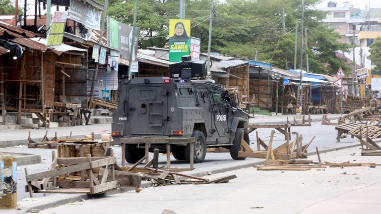 A Tanzanian police vehicle drives along a road barricaded by demonstrators. Pic Reuters