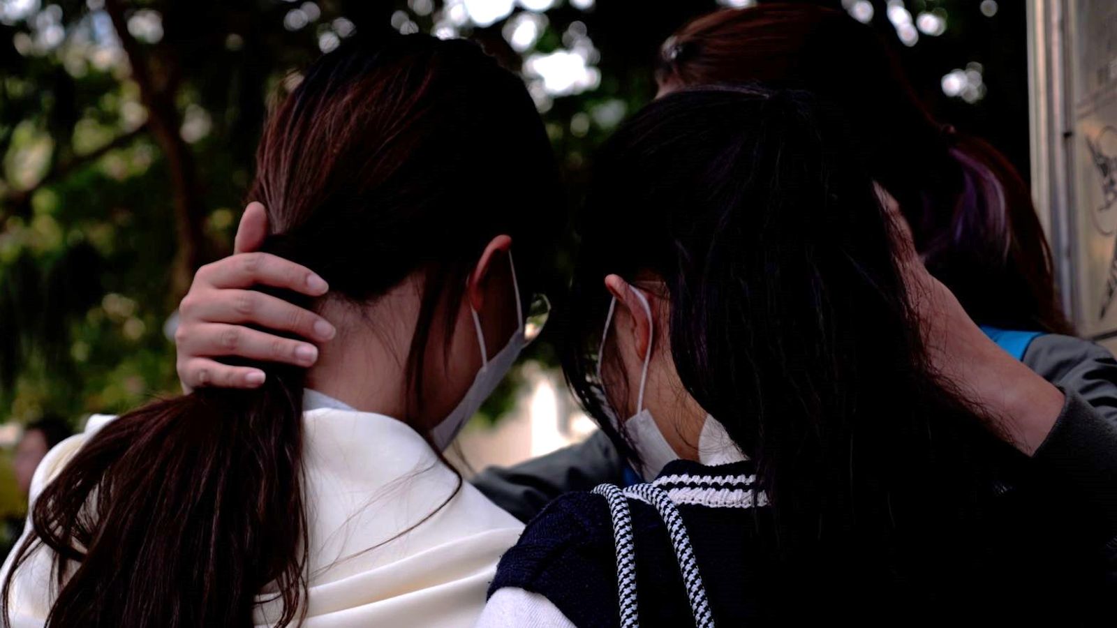 Survivors cling to each other as debris falls from smouldering Hong Kong buildings