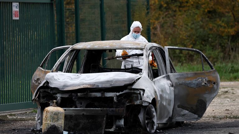 A French officer inspects the burnt car used by the driver. Pic: Reuters