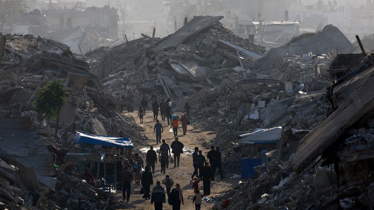 Palestijnen lopen tussen stapels puin, te midden van een staakt-het-vuren tussen Israël en Hamas, in de noordelijke Gazastrook. Afbeelding: Reuters