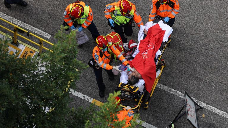 An injured firefighter is taken to an ambulance. Pic: Reuters