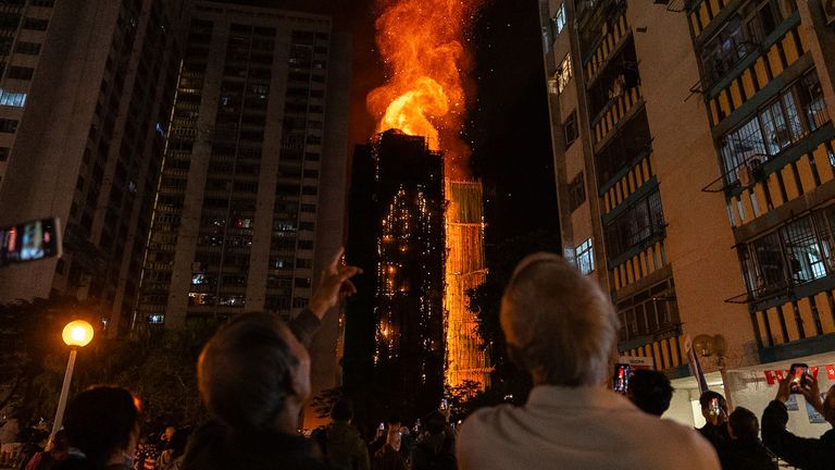 People look at flames engulfing a building after a fire broke out at Wang Fuk Court on 26 November. Pic: AP