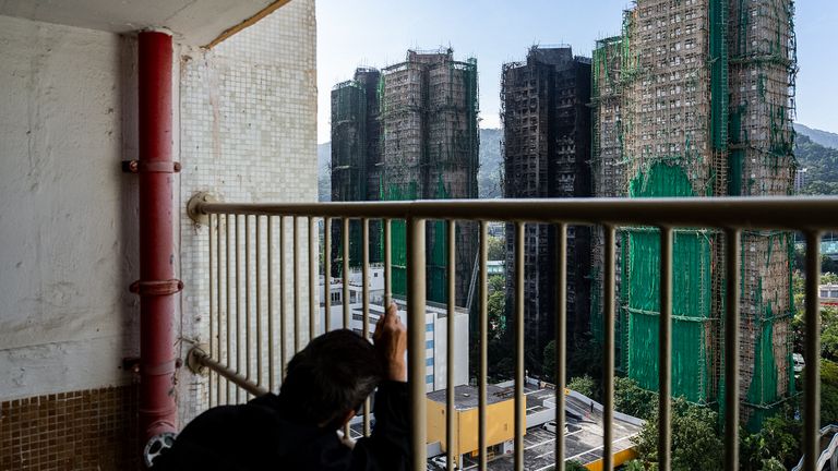 A resident looks at the burned buildings. Pic: AP