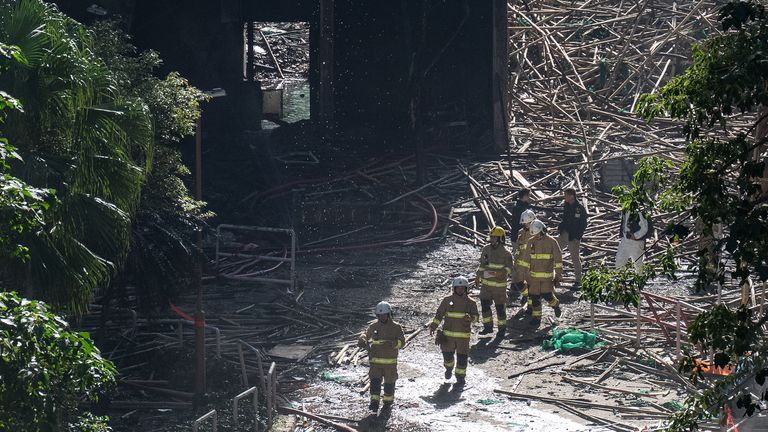 Bombeiros caminham entre edifícios queimados após o incêndio mortal. Foto: AP