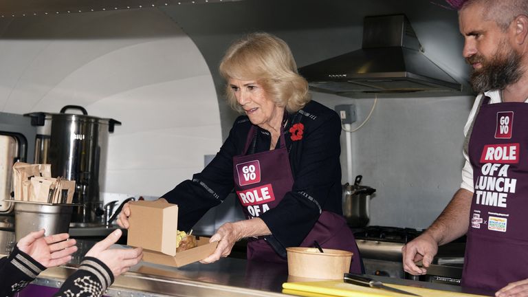 Queen Camilla helps Spudman prepare food as he delivers jacket potatoes in a Royal Voluntary Service food truck.
Pic Reuters