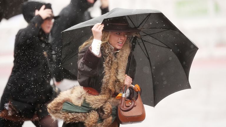 People brave the rain at Cheltenham Racecourse. Pic: PA