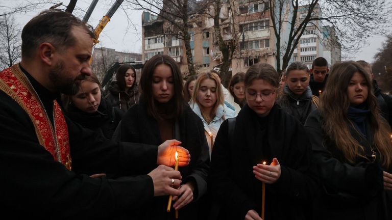 Um coro canta em frente a um prédio destruído por um ataque de mísseis russos em Ternopil, na Ucrânia. Foto: Reuters