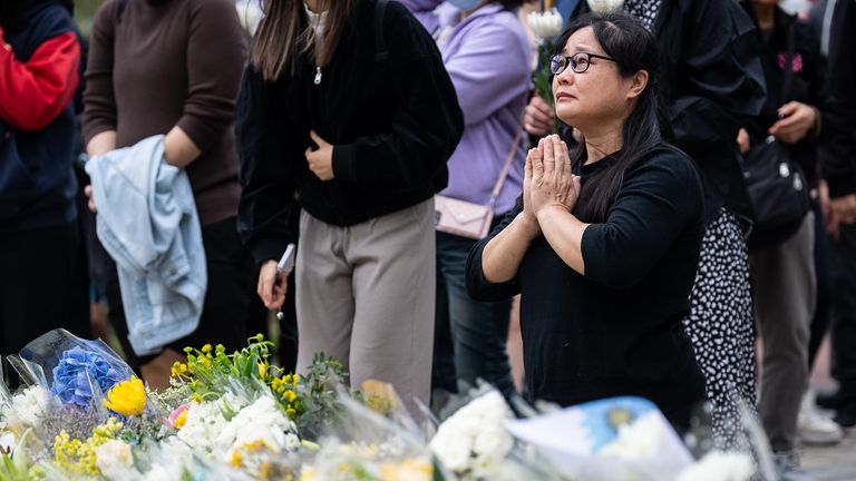 People offer flowers and pray for the victims. Pic: AP