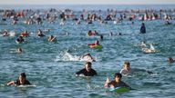 Surfers and swimmers pay tribute at Bondi Beach on 19 December. Pic: AP 