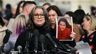 Jess Michaels holds up her picture as she speaks during a press conference on the Epstein Files Transparency Act. Pic: Reuters