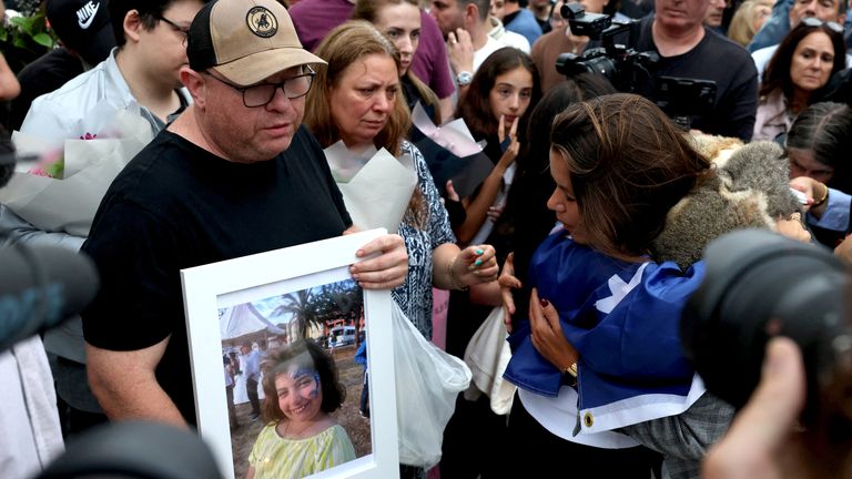 Matilda's father holds a photo of his daughter at a vigil on Bondi Beach. Pic: Reuters
