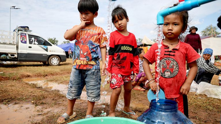 Children fill containers with clean water at Chong Kal refugee camp in Cambodia. Pic: Reuters