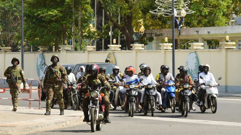 Soldiers stand guard in front of the radio and television station HQ in Cotonou. Pic: Reuters